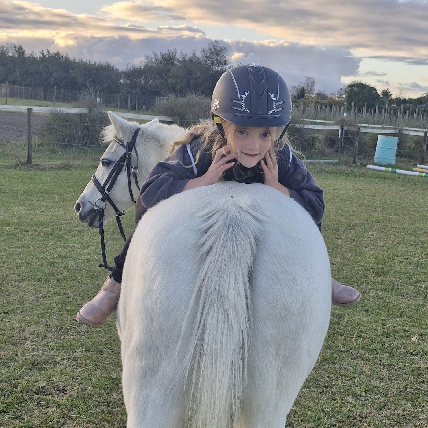 A rider hugging her pony after a lesson